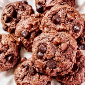 several chocolate chip cake mix cookies on a scalloped cream colored plate.