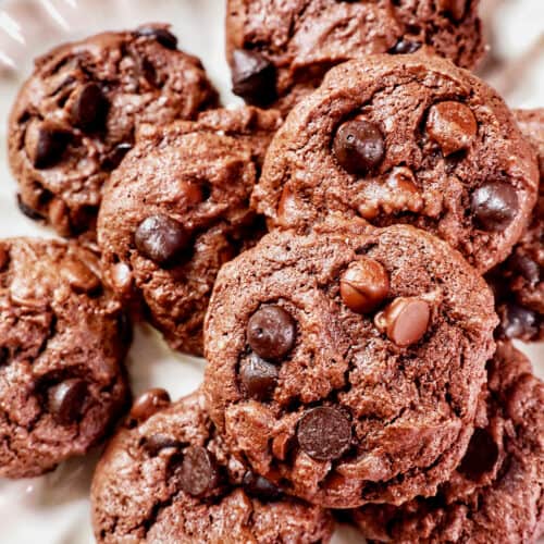 several chocolate cake mix cookies on a scalloped cream colored plate.