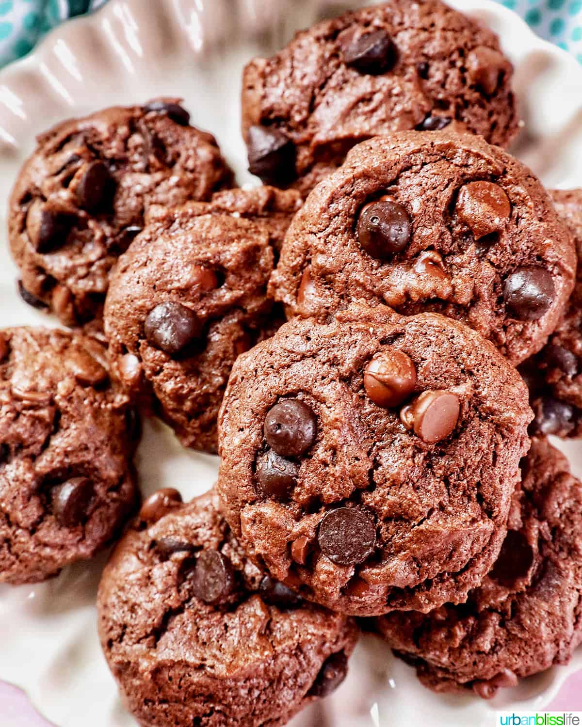 several chocolate cake mix cookies on a scalloped cream colored plate.