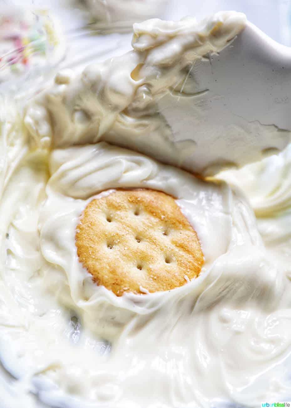 dipping Ritz cracker cookies into white chocolate