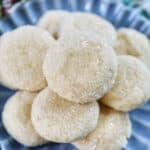 stack of soft almond sugar cookies on a blue plate.