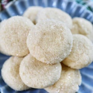 stack of soft almond sugar cookies on a blue plate.