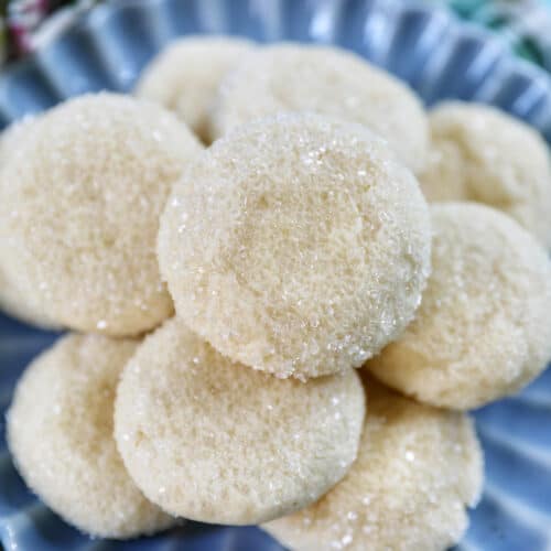 stack of soft almond sugar cookies on a blue plate.
