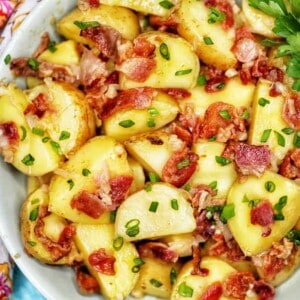 landscape photo of a bowl of baby potato salad with bacon with colorful napkin