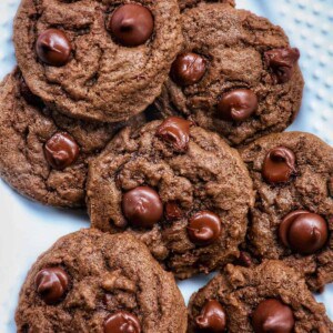 several double chocolate coffee cookies layered on a white plate.