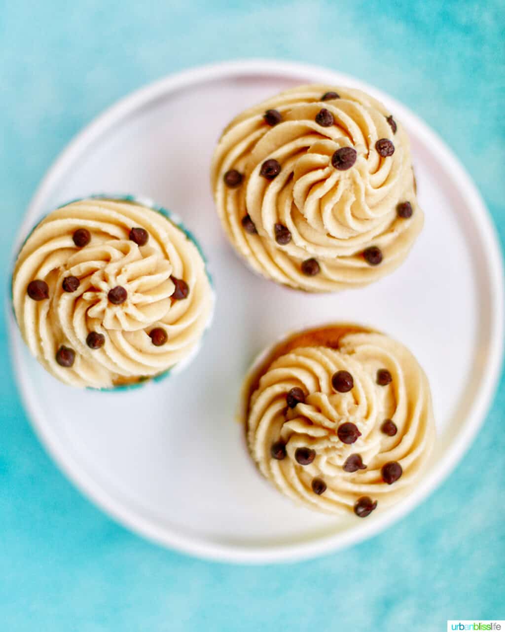 three cupcakes looking down at the cookie dough frosting tops with chocolate chips
