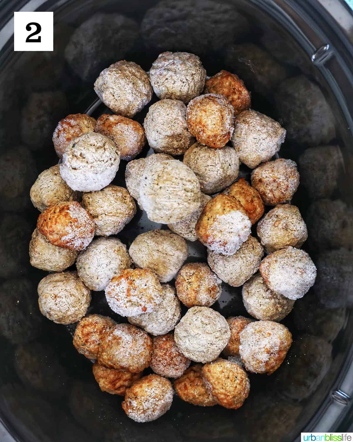 frozen meatballs placed inside the bowl of a slow cooker.