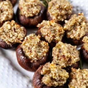 Vegan Stuffed Mushrooms close together on a white platter.
