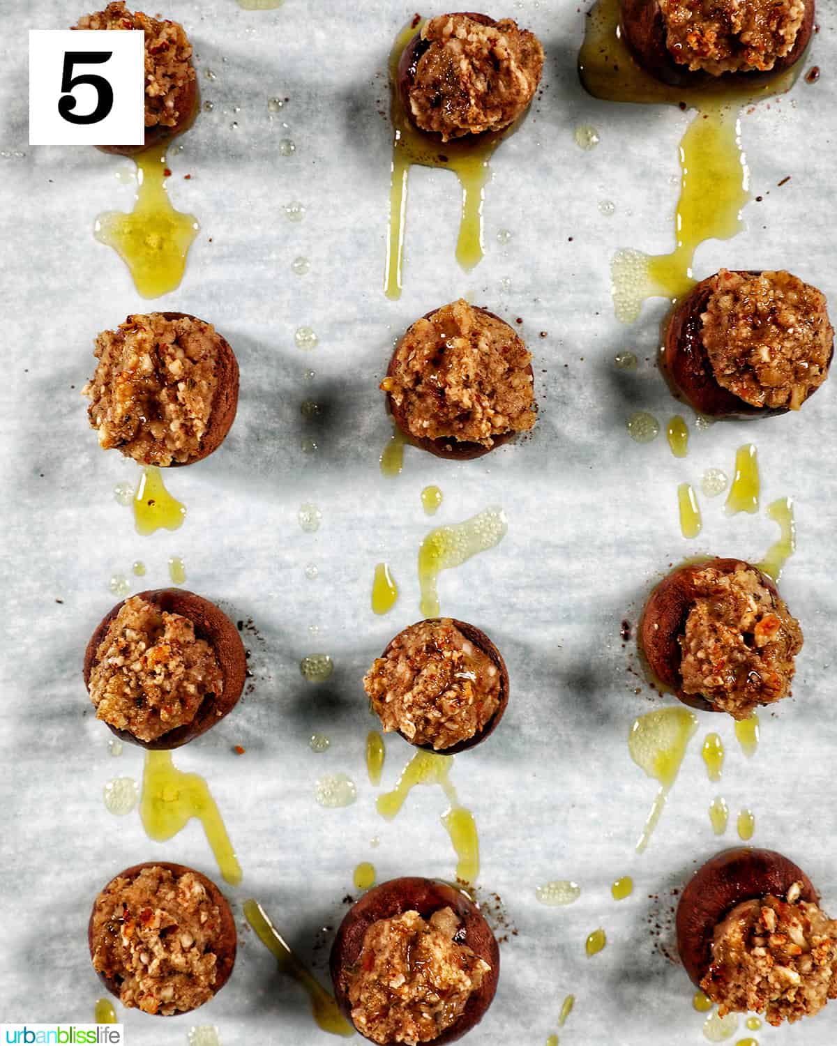 a dozen Vegan Stuffed Mushrooms placed in rows on a baking sheet.