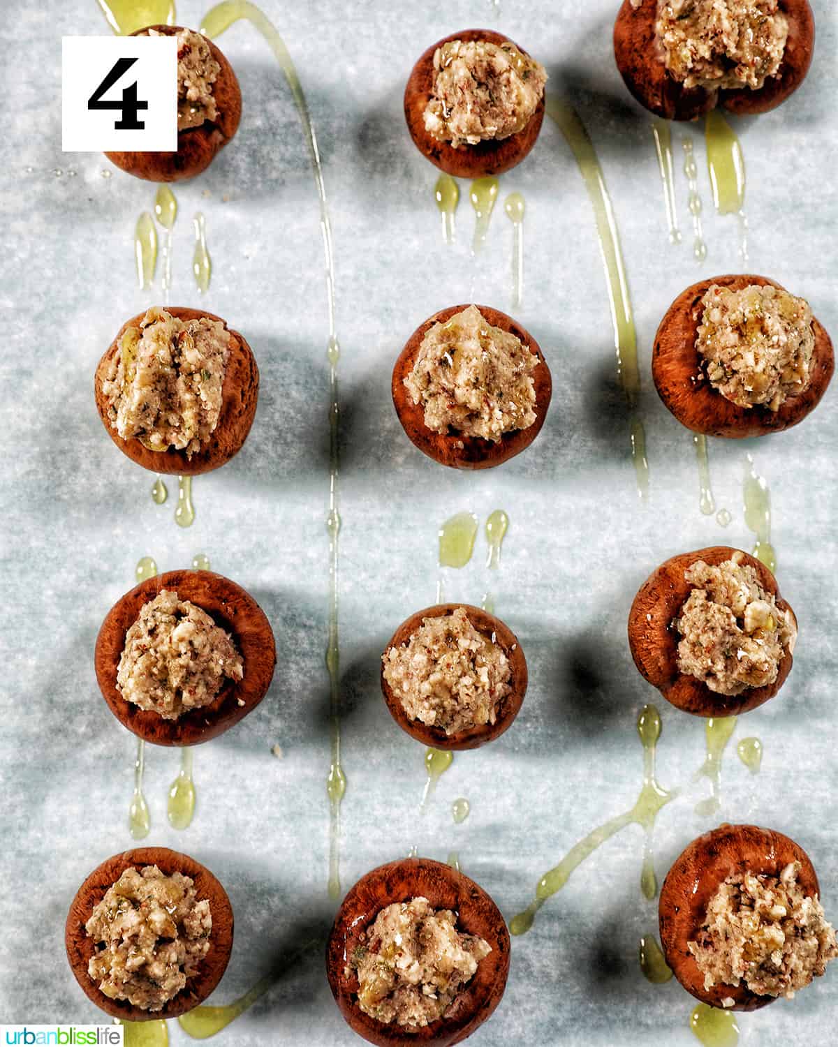 a dozen Vegan Stuffed Mushrooms placed in rows on a baking sheet.