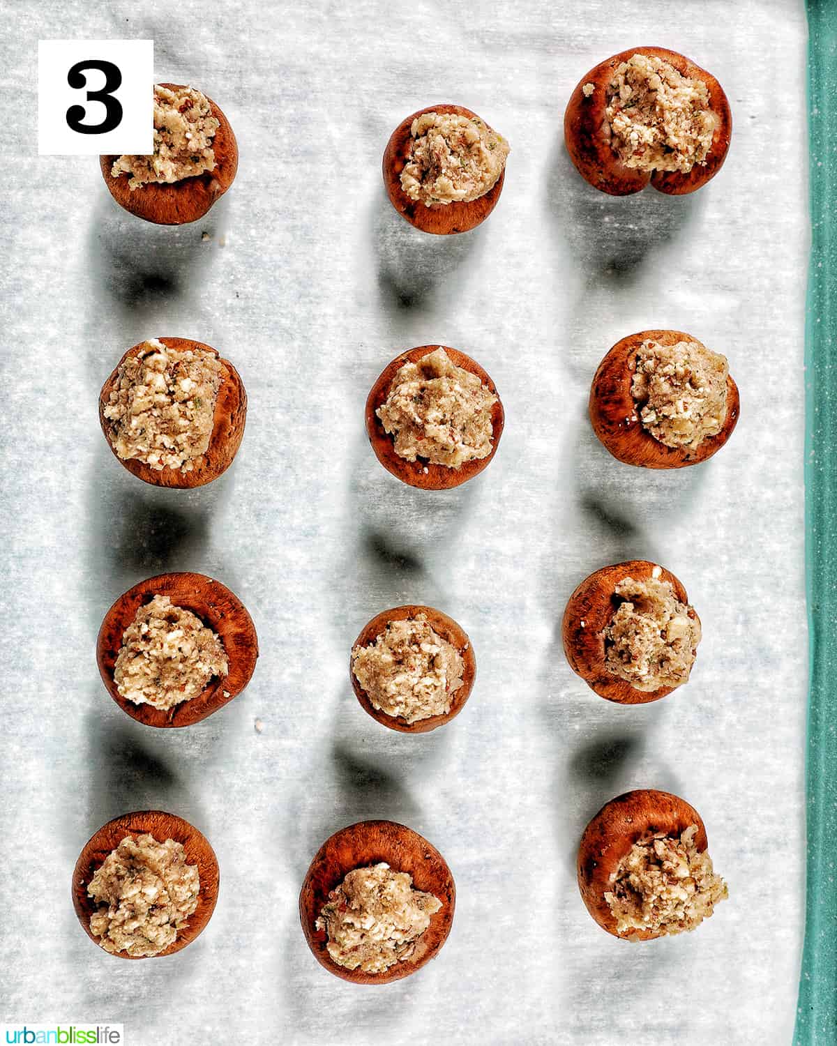 a dozen Vegan Stuffed Mushrooms placed in rows on a baking sheet
