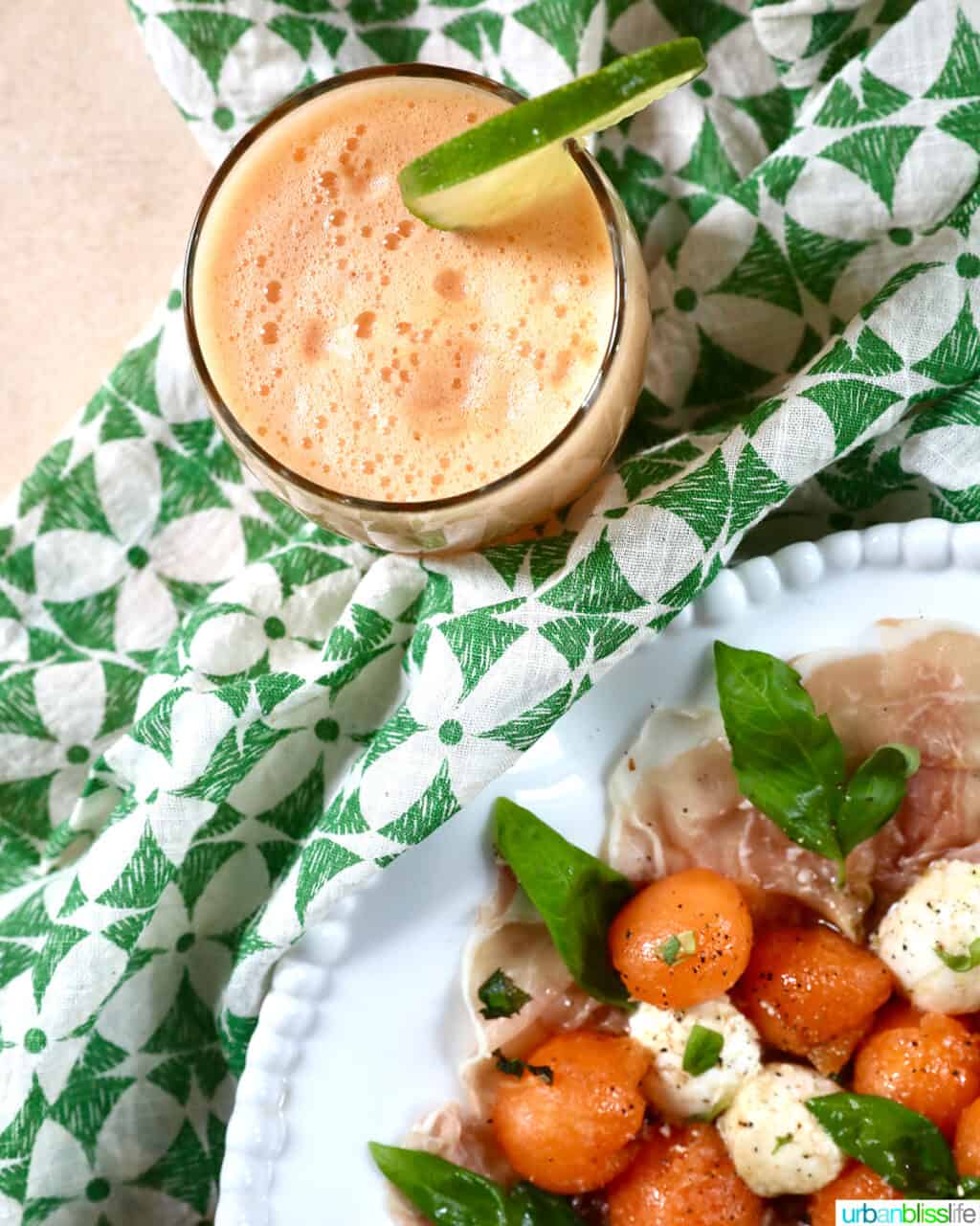 melon prosciutto caprese salad on a green and white napkin with a glass of cantaloupe margarita.