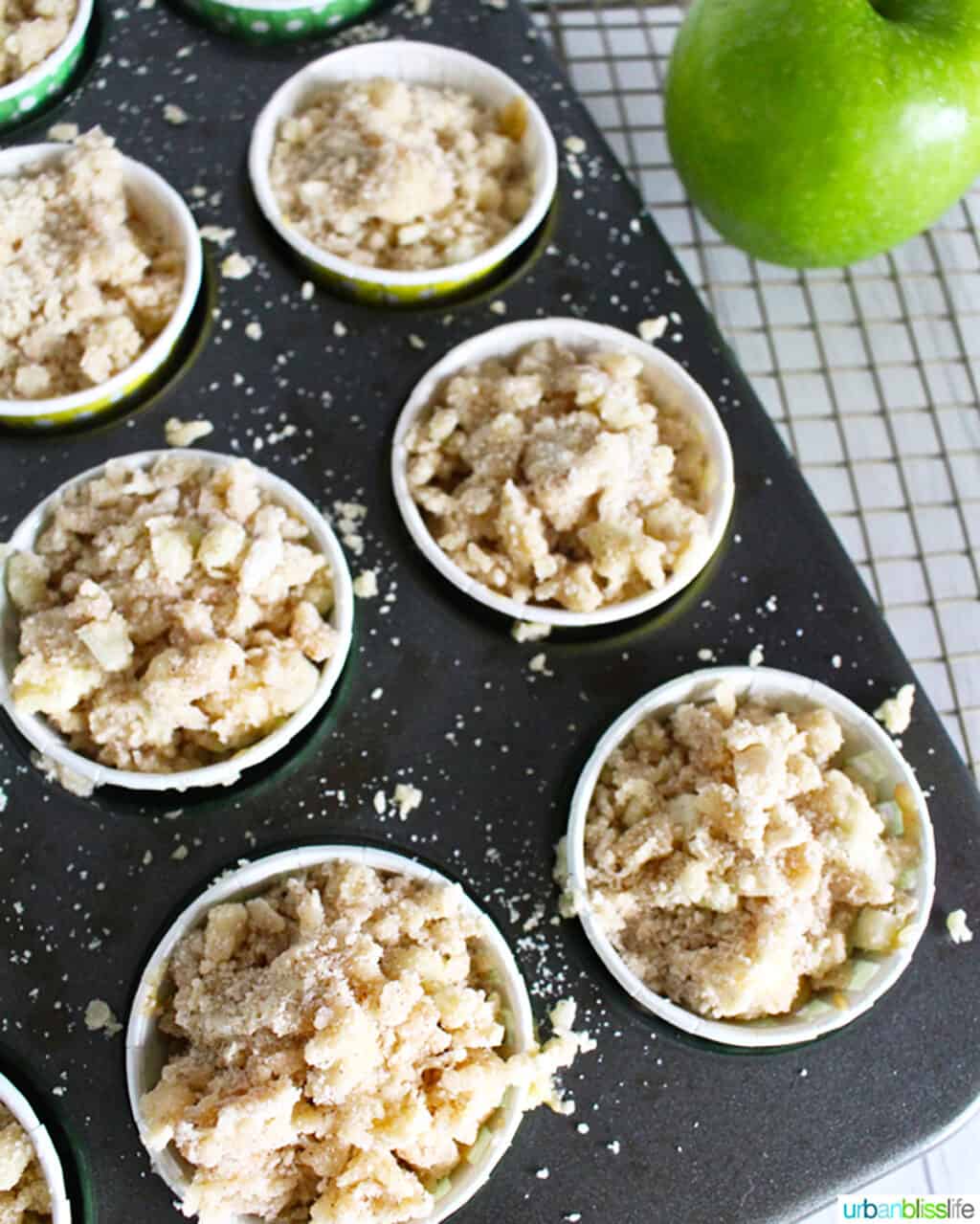 batter for apple cinnamon streusel muffins in muffin tin ready to bake.