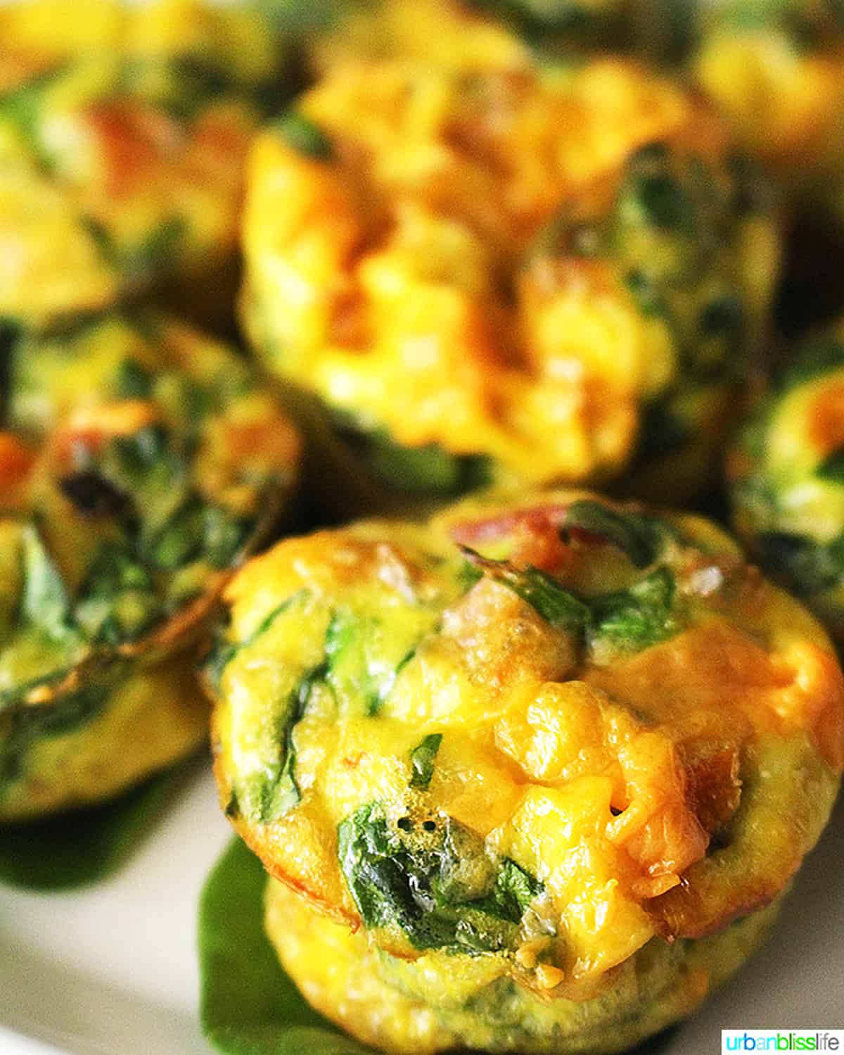 several cheesy spinach mini frittatas stacked.