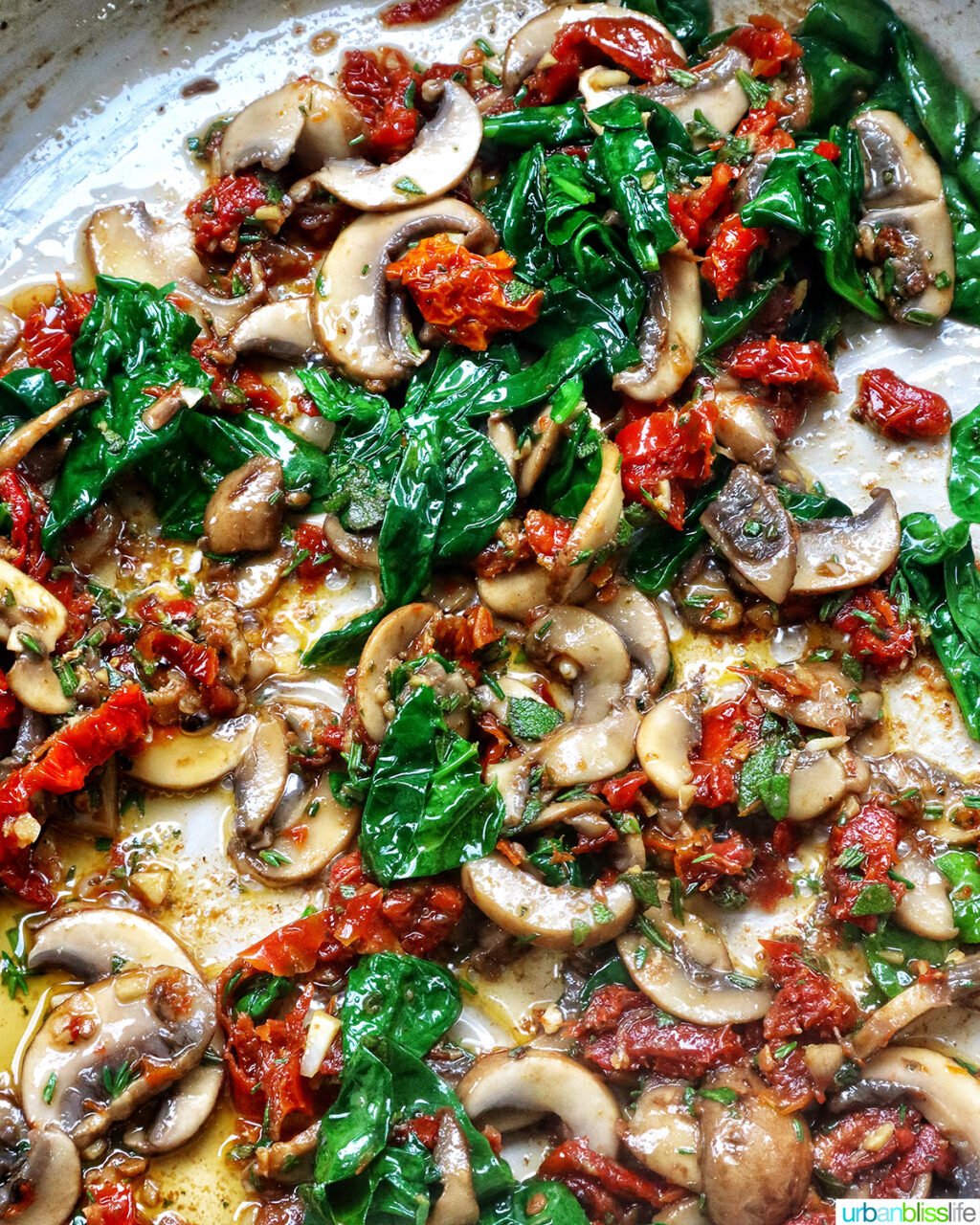 spinach, mushrooms, herbs in a pan with olive oil.