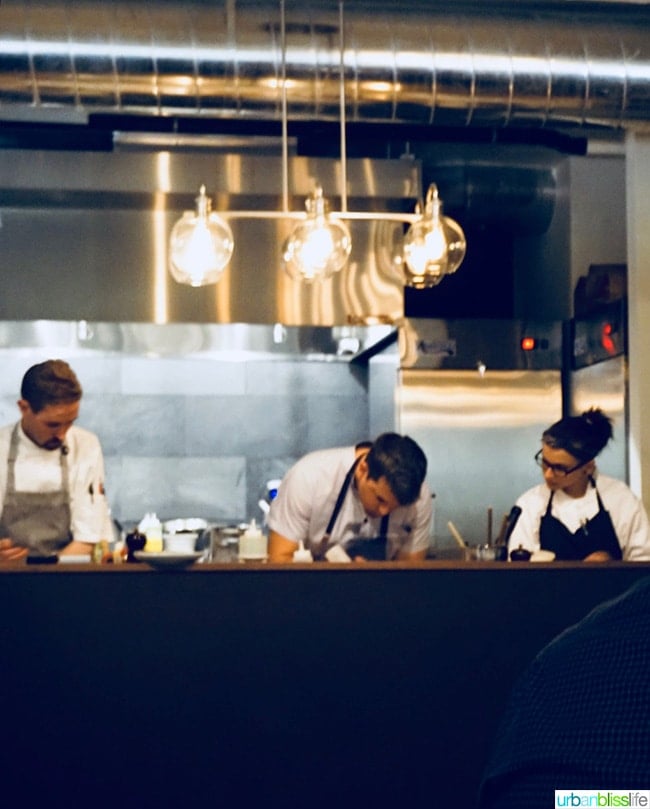 Restaurant kitchen with three chefs cooking.