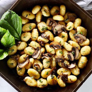 cast iron skillet with gnocchi, mushrooms, basil.