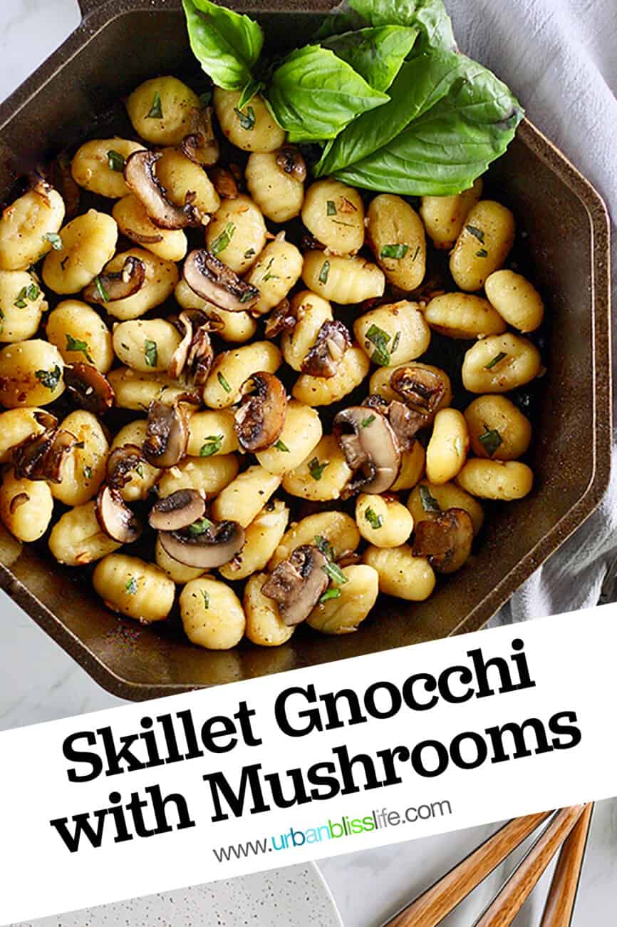cast iron skillet with gnocchi, mushrooms, basil and title text.
