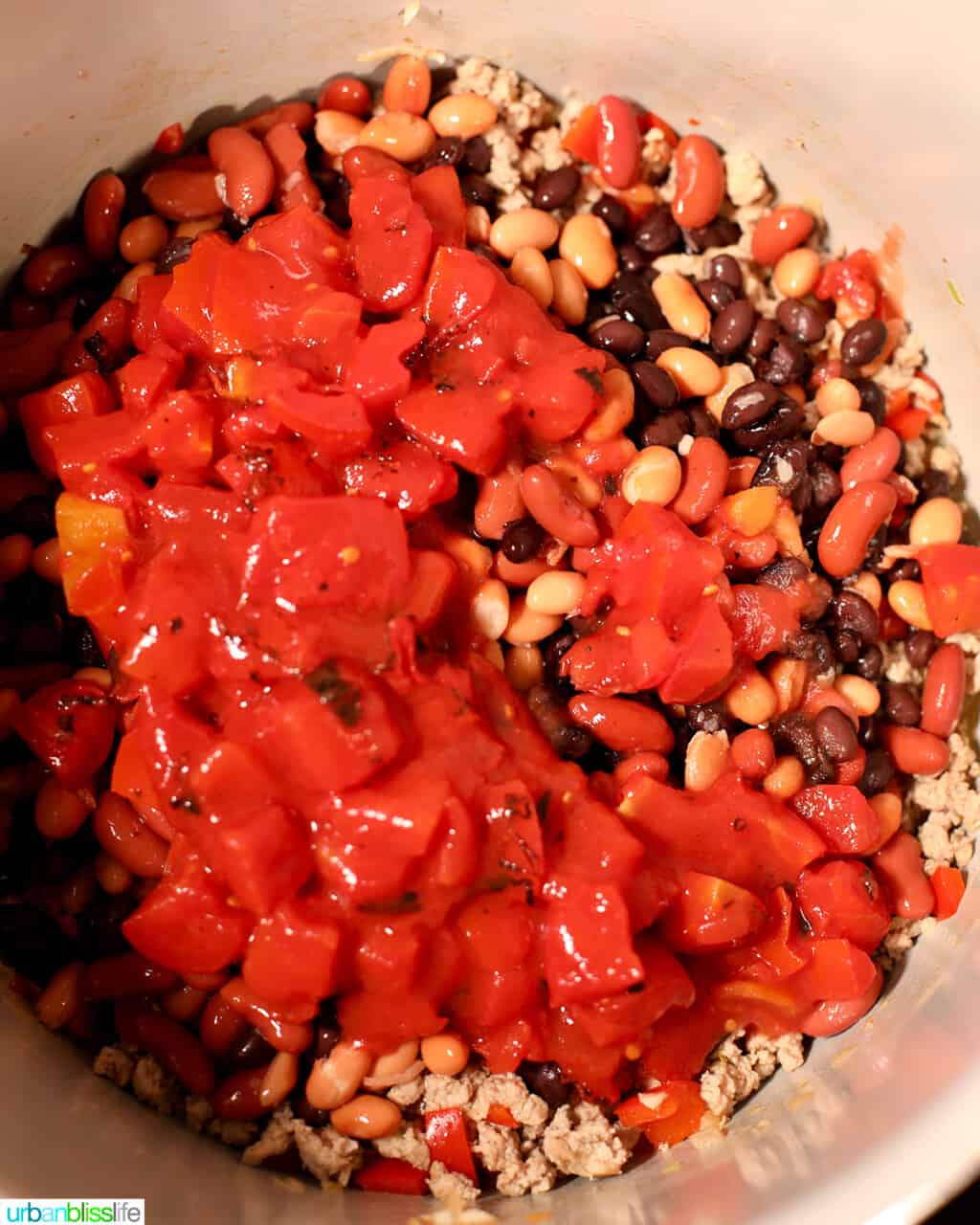 adding diced tomatoes to ninja foodi chili
