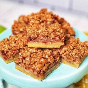 stack of apple pie bars on a light blue cake pedestal