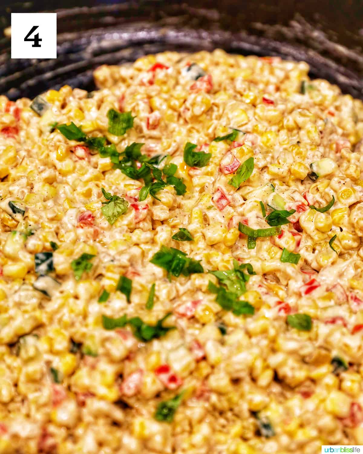 mixed cream cheese confetti corn with green onions in a large skillet.