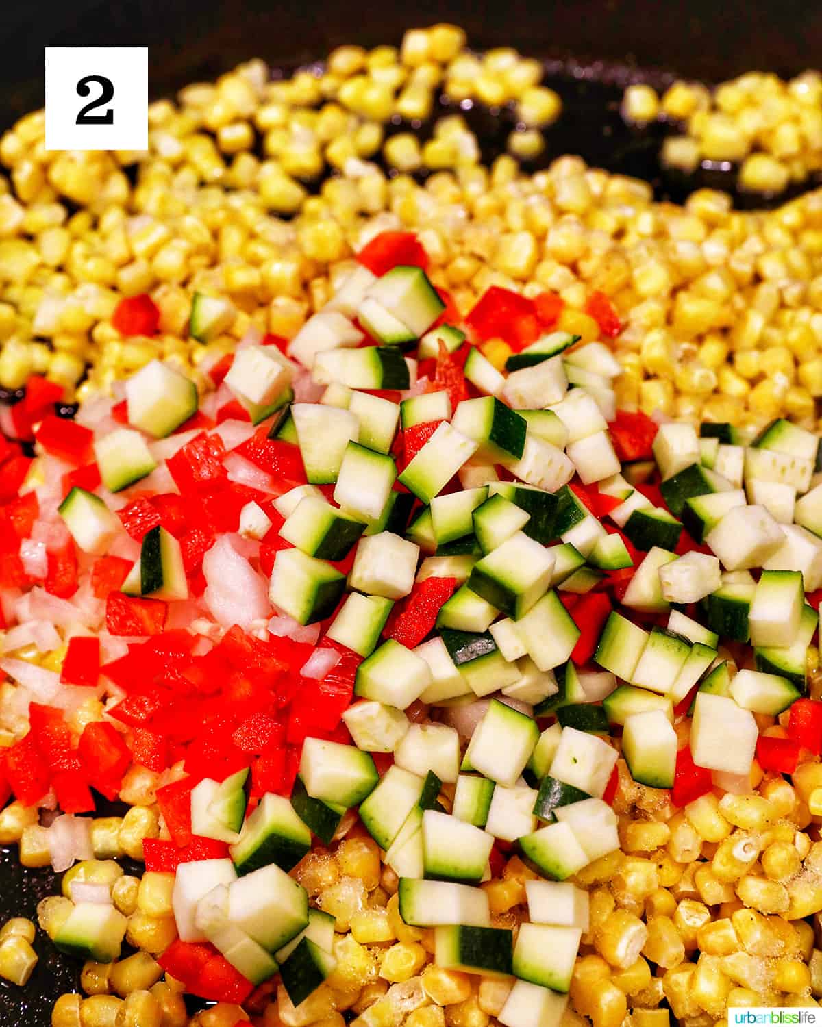 chopped zucchini, red bell peppers, and corn cooking in a large skillet.