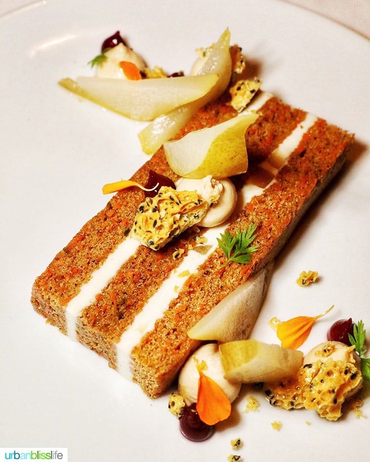carrot cake with various colorful garnishes on a white plate at RingSide Steak House in Portland, Oregon.