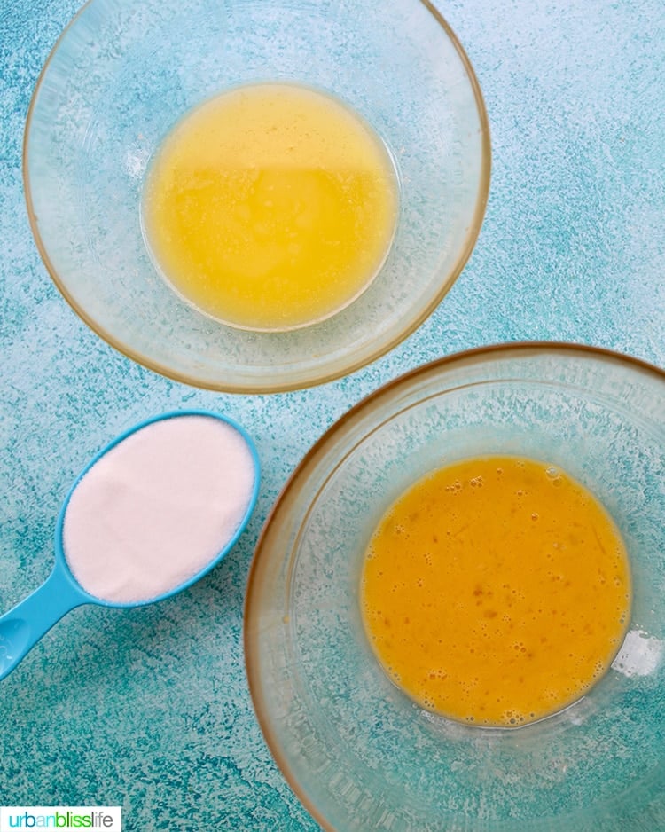 ingredients for pineapple bread - sugar, eggs, melted butter - in clear glass bowls on a blue background.