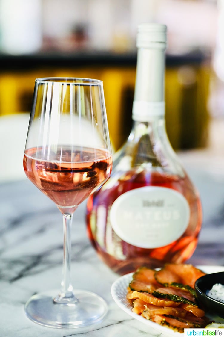 Mateus Rosé wine glass and bottle behind it.