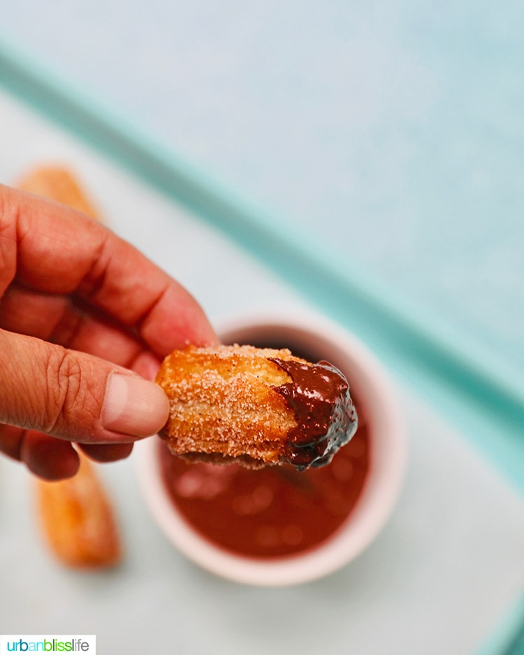 dipping a churro bite into chocolate