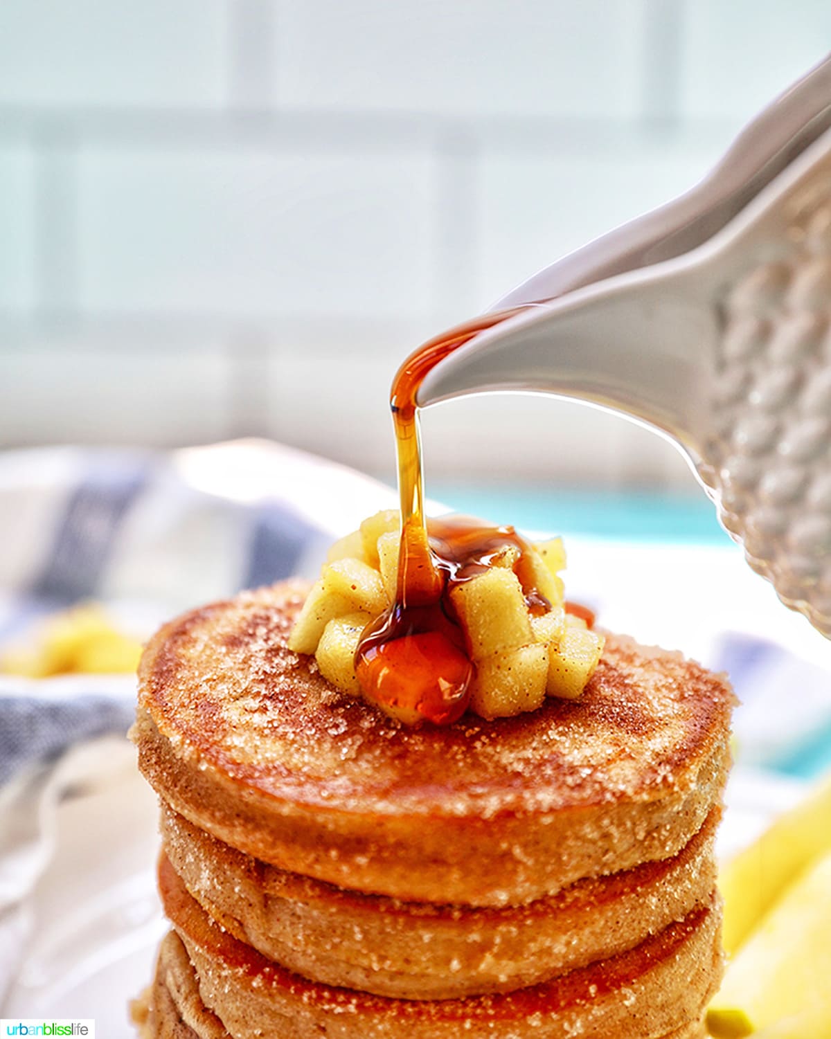 pouring maple syrup over pancakes