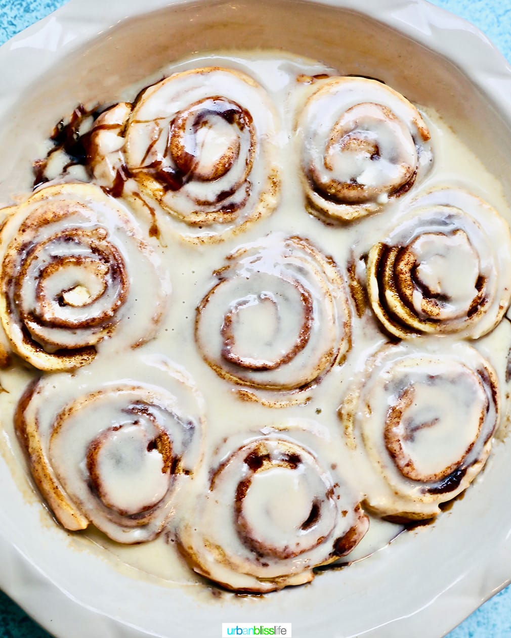 full baking dish of iced orange cardamom cinnamon rolls.