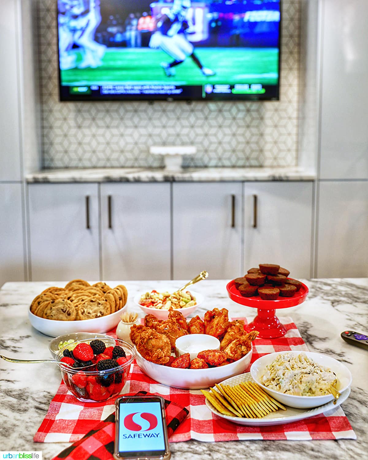 football on the tv in background with football food spread in foreground