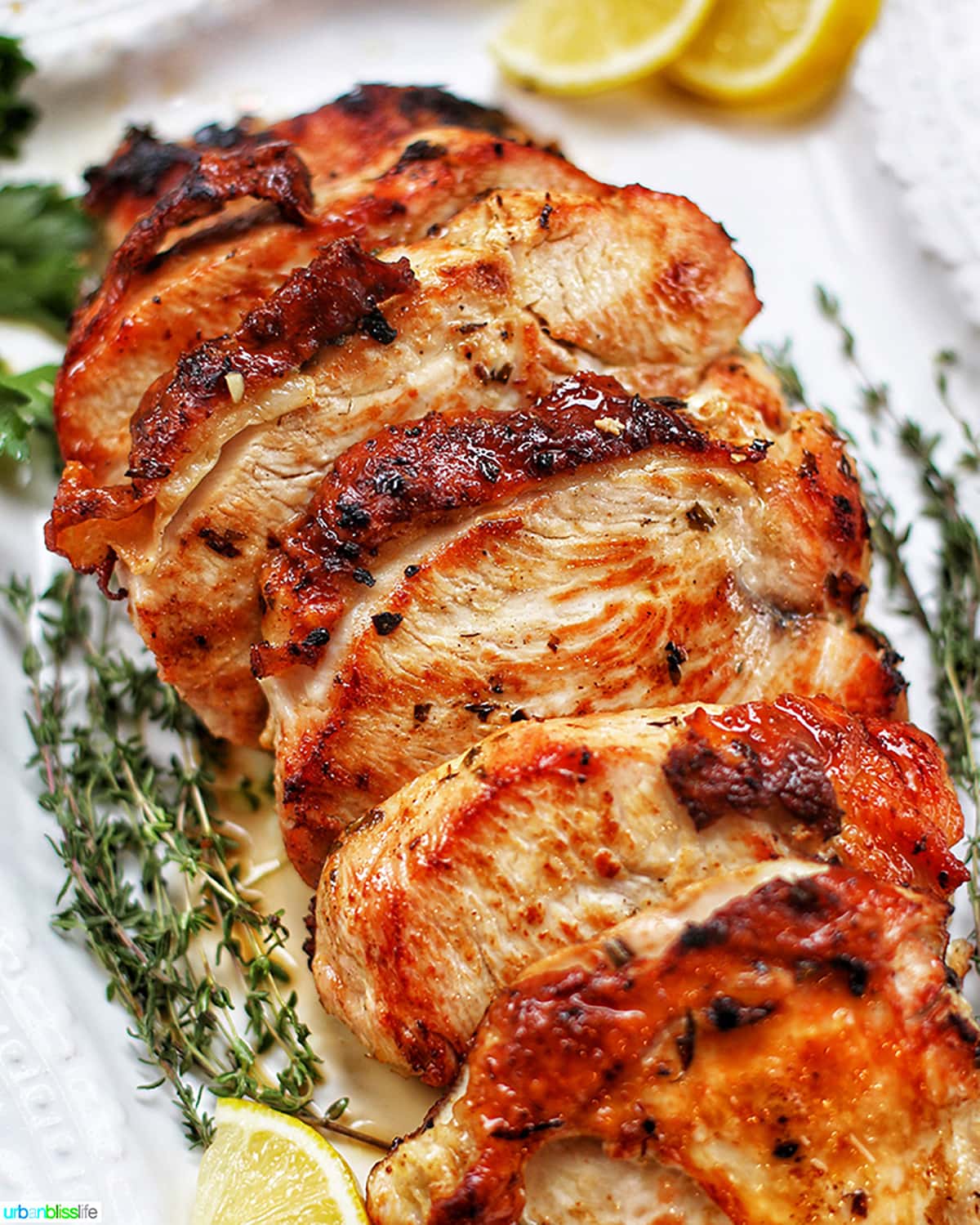 angled photo of sliced Citrus Herb Turkey Breast on white platter.