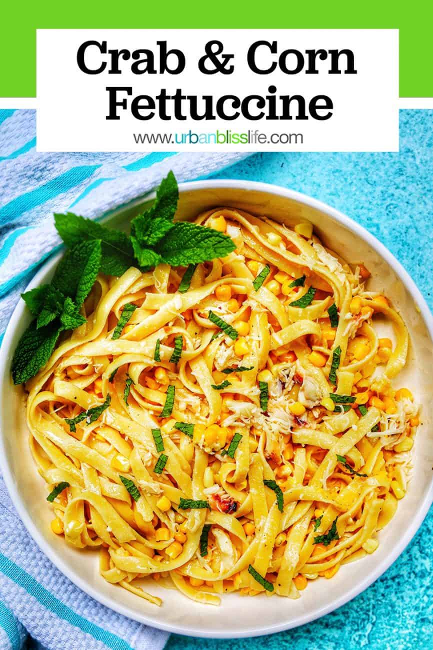 crab and corn fettuccine in bowl on blue background with title text