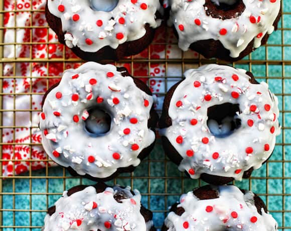 six mini gingerbread bundt cakes on a baking rack with red and white napkin