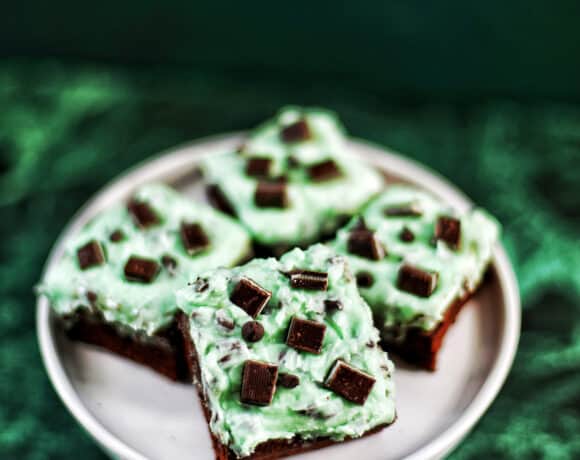 Mint Chocolate Chip Brownies on a cake pedestal on green background