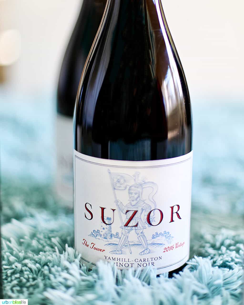 bottle of Suzor Oregon Pinot Noir on fluffy blue blanket