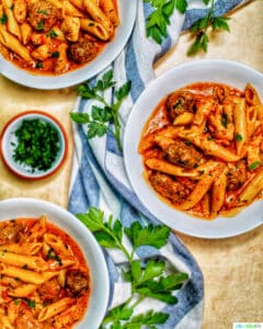 bowls of Instant Pot Cajun Chicken Pasta with greenery