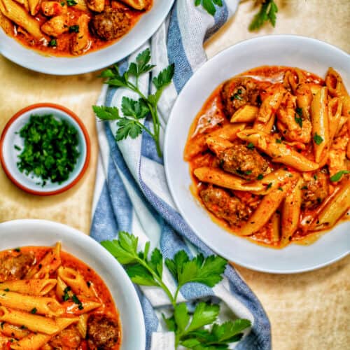 bowls of Instant Pot Cajun Chicken Pasta with greenery