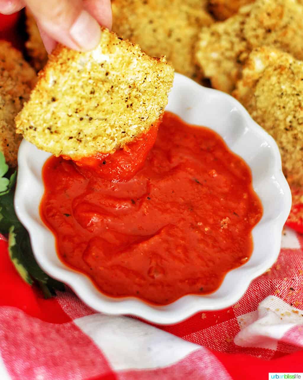 dipping air fryer ravioli into sauce