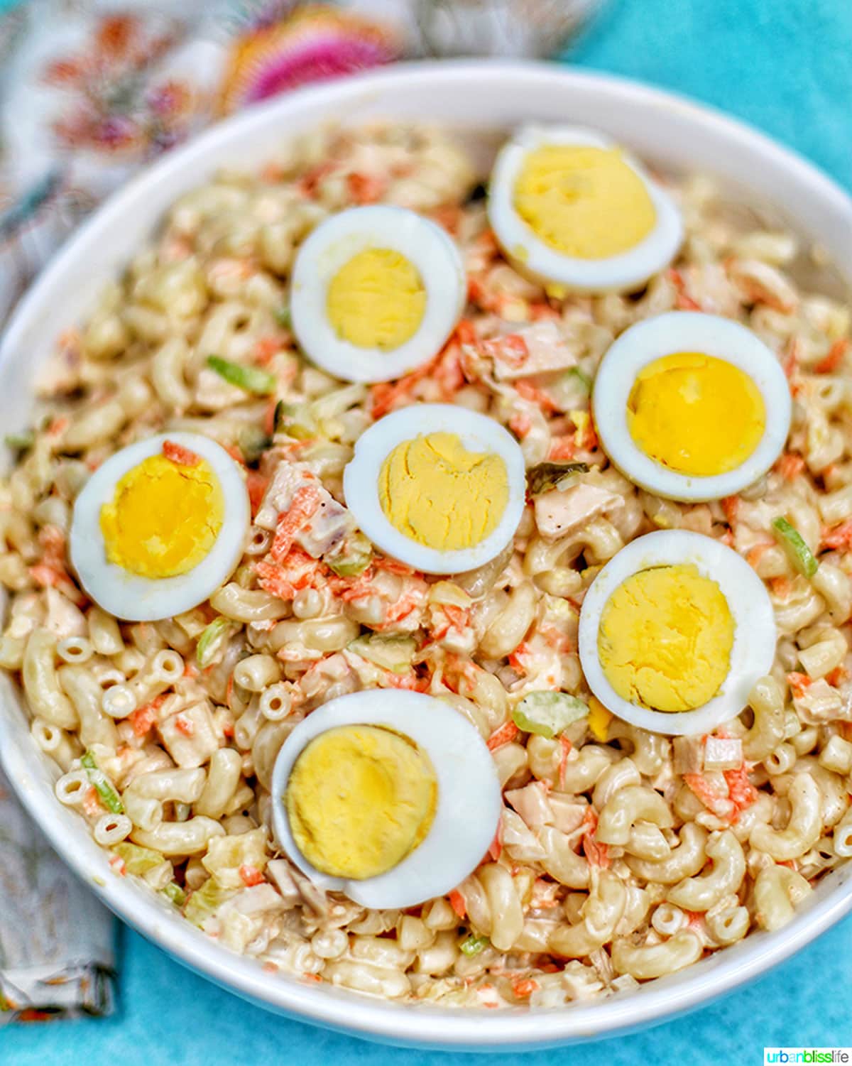 Filipino Macaroni Salad - macaroni, carrots, chicken, celery, pineapple, sliced hard-boiled egg- in a bowl.