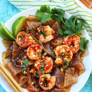 plate of wide glass noodles with shrimp and fresh herbs.