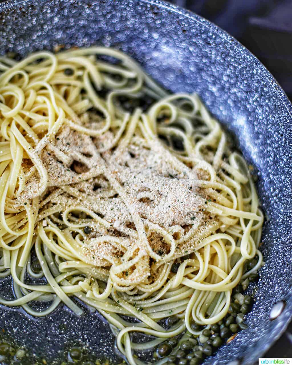 adding pasta to sauce in skillet