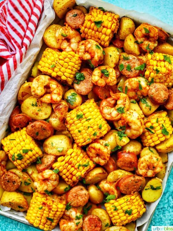 tray of seafood, corn, sausage low country boil with blue background and red and white towel