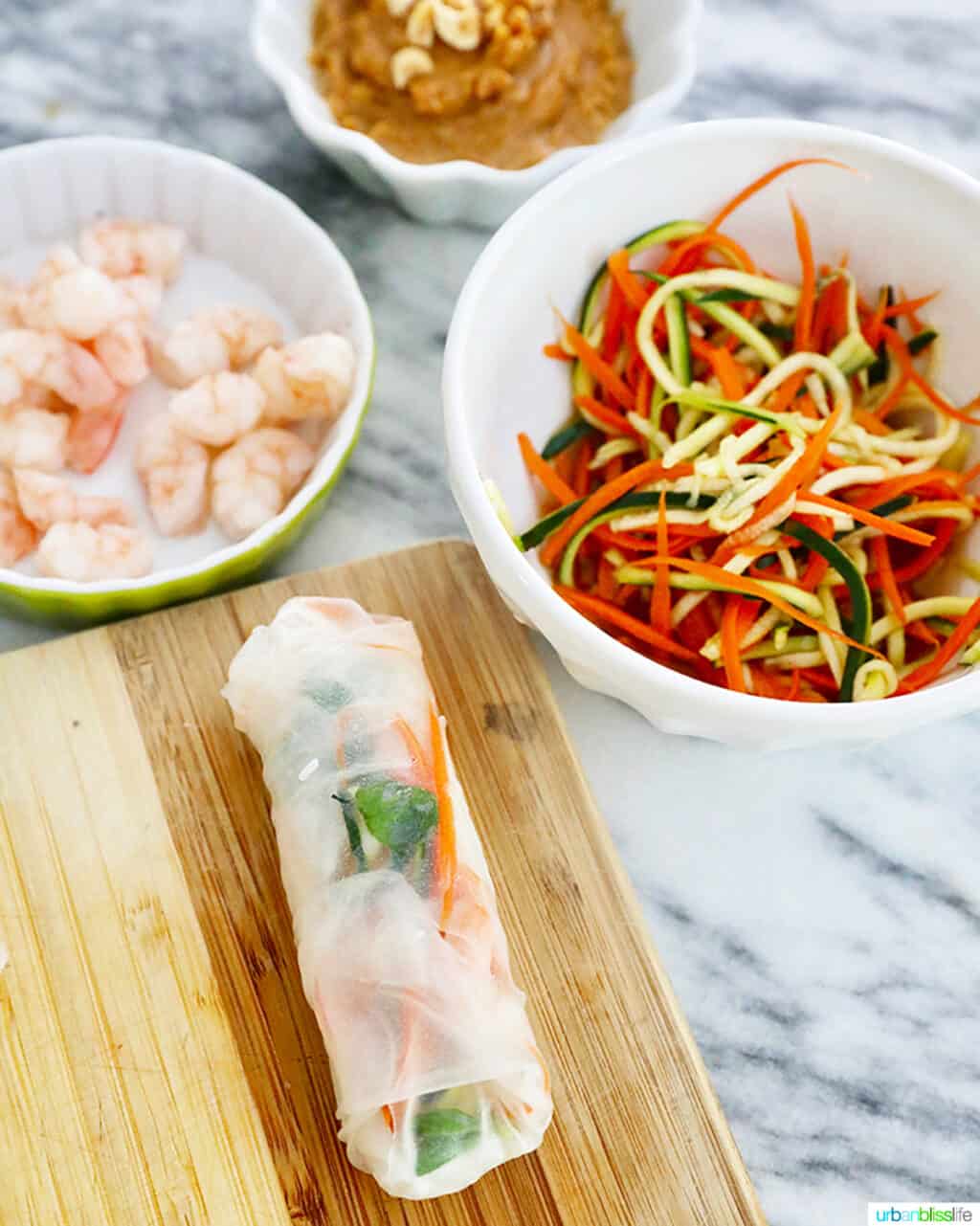 one shrimp roll assembled with ingredients in bowls