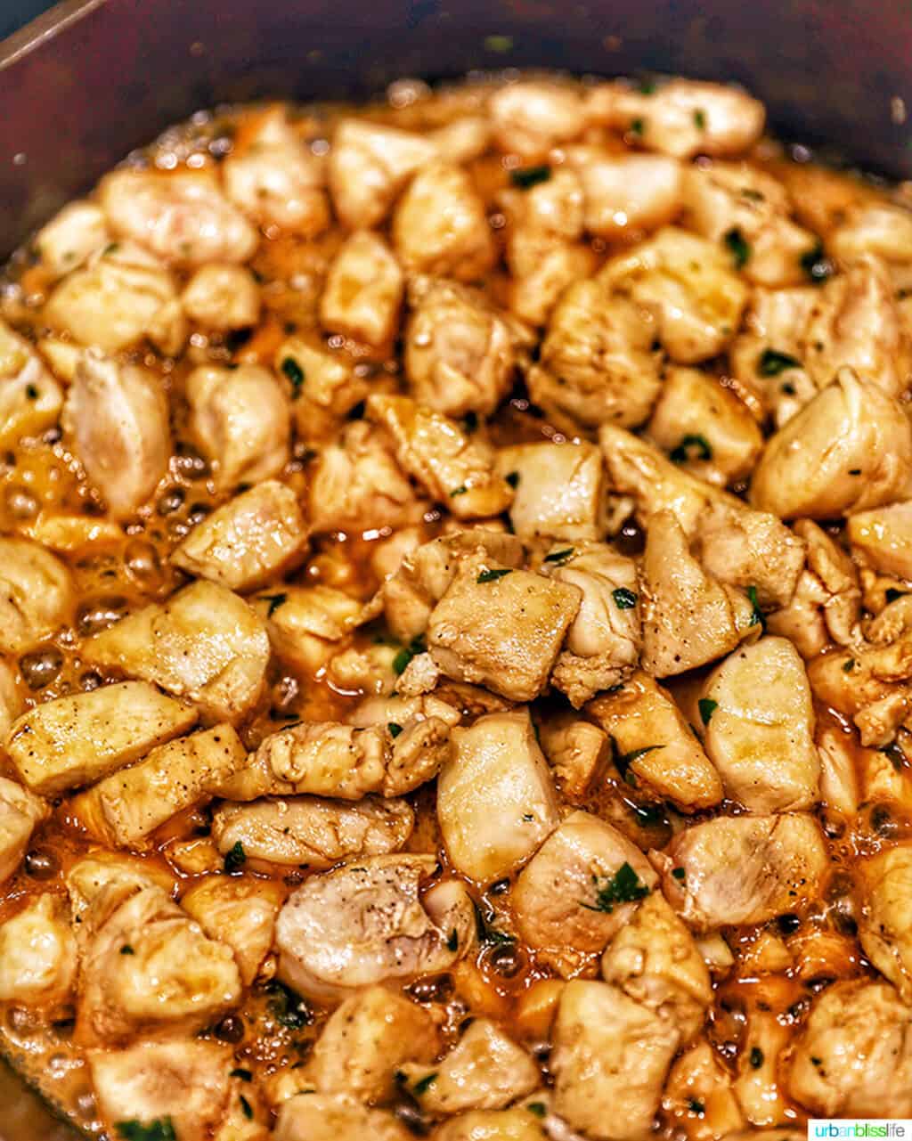 soy garlic butter chicken bites cooking in a cast iron pan