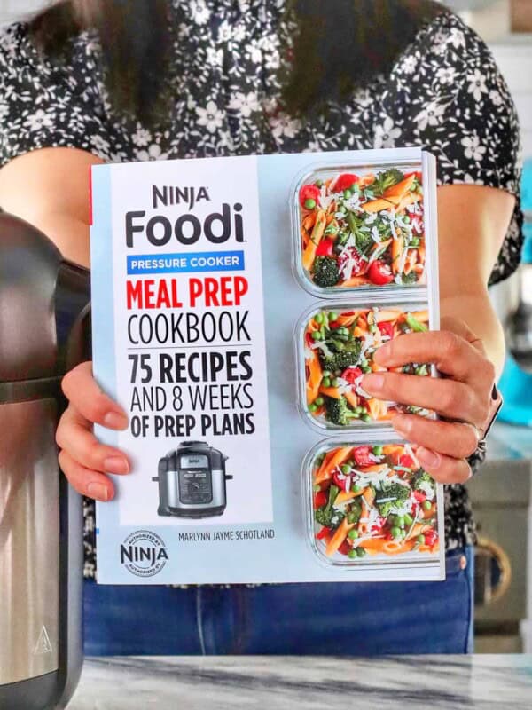 hands holding Ninja Foodi Meal Prep Cookbook