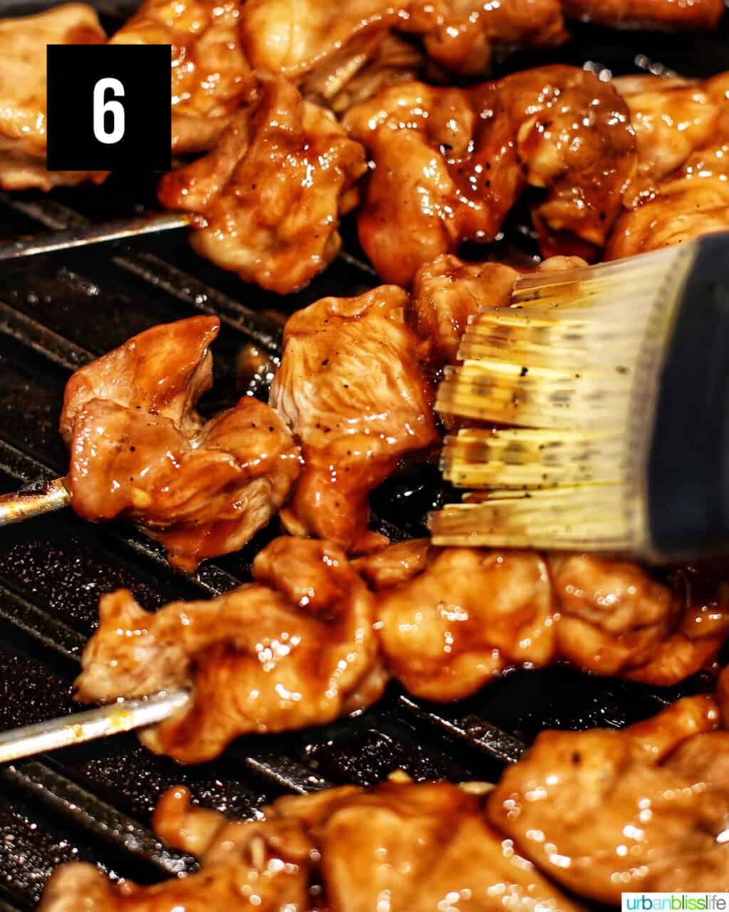 basting Filipino BBQ pork skewers on the grill