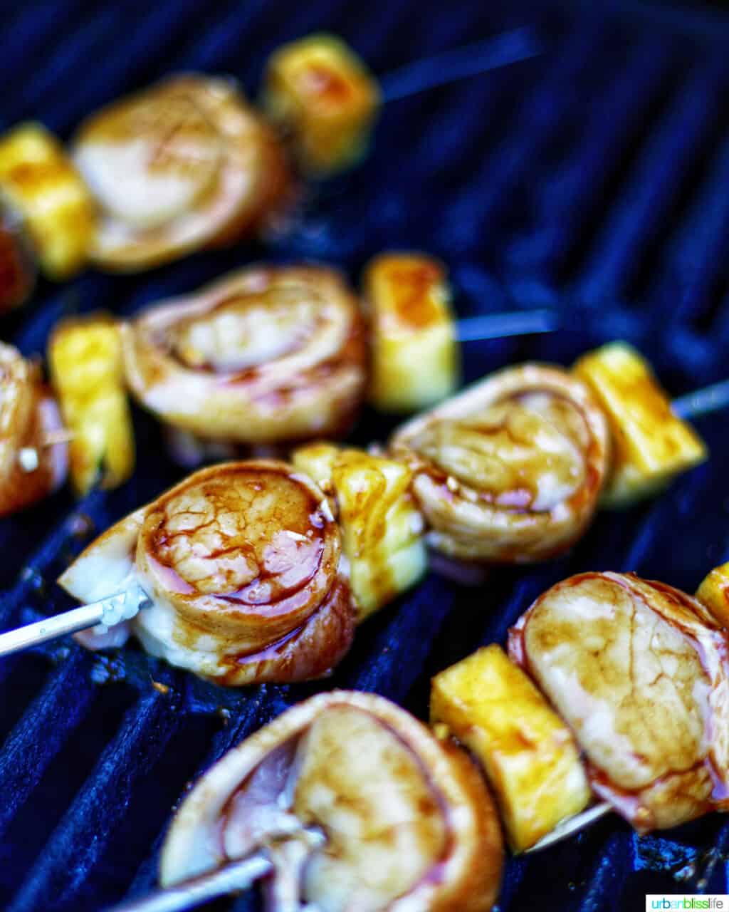 grilled bacon-wrapped scallop skewers with pineapple on the grill